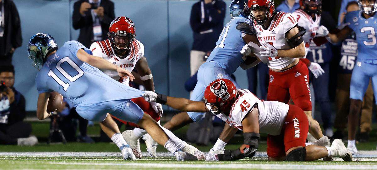 N.C. State defensive tackle Davin Vann (45) sacks North Carolina quarterback Drake Maye (10) for a loss of four-yards during the second half of N.C. State’s 30-27 overtime victory over UNC at Kenan Stadium in Chapel Hill, N.C., Friday, Nov. 25, 2022.