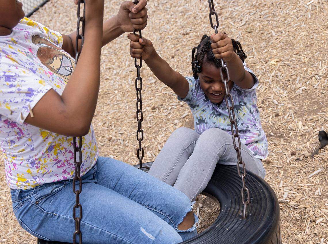 Naazira Burnette, 8, right, smiles while playing on a tire swing at Walltown Park on Tuesday, June 13, 2023, in Durham, N.C.