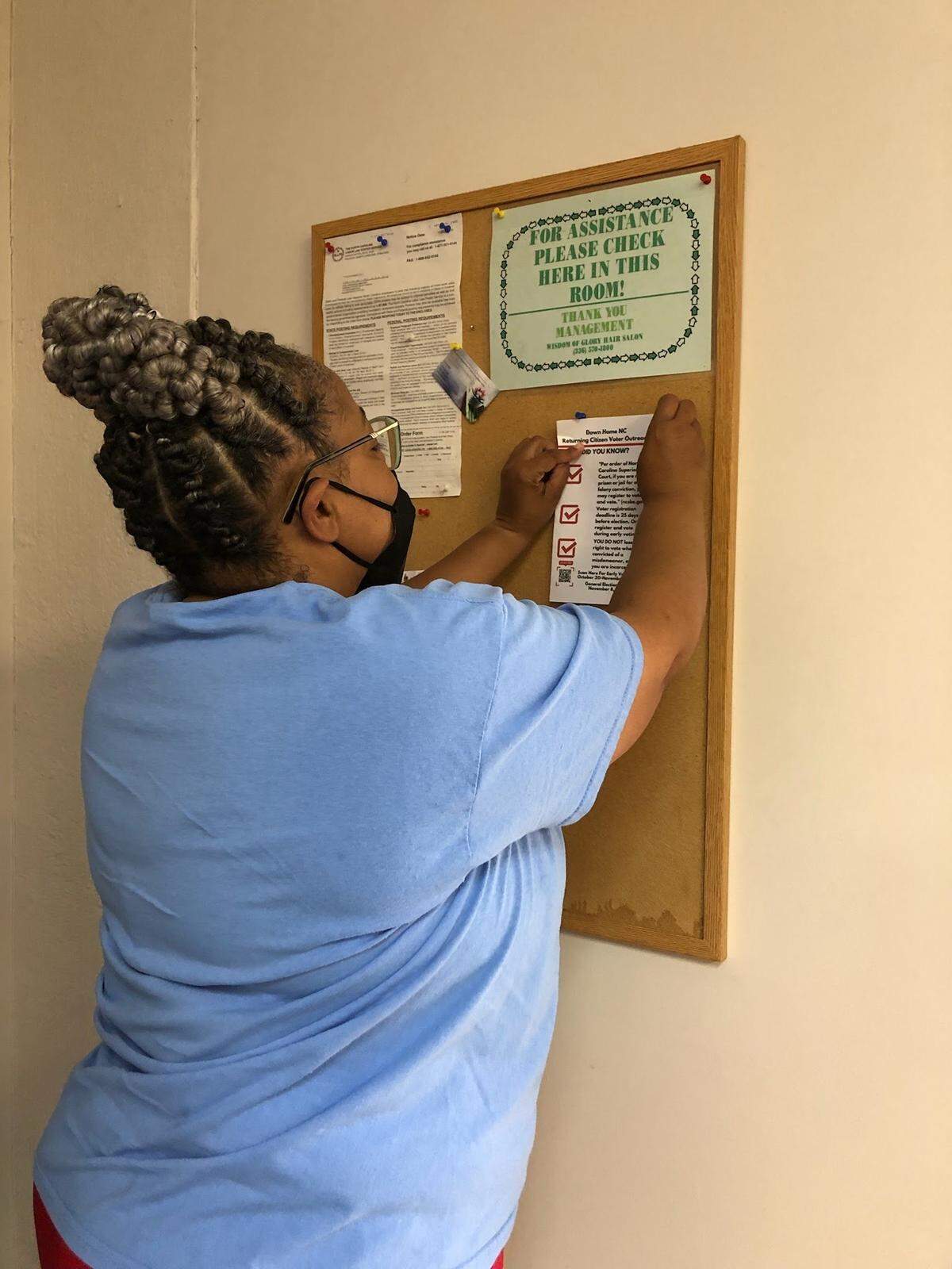 Donna VanHook hangs a flyer up in a local beauty shop in Burlington.