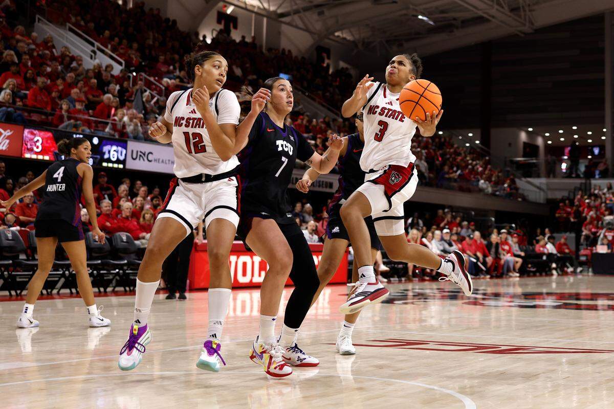 Zamareya Jones (3) of N.C. State goes to the basket against Marta Suarez (7) of TCU in the first half at Reynolds Coliseum on Nov. 16, 2025 in Raleigh, North Carolina.