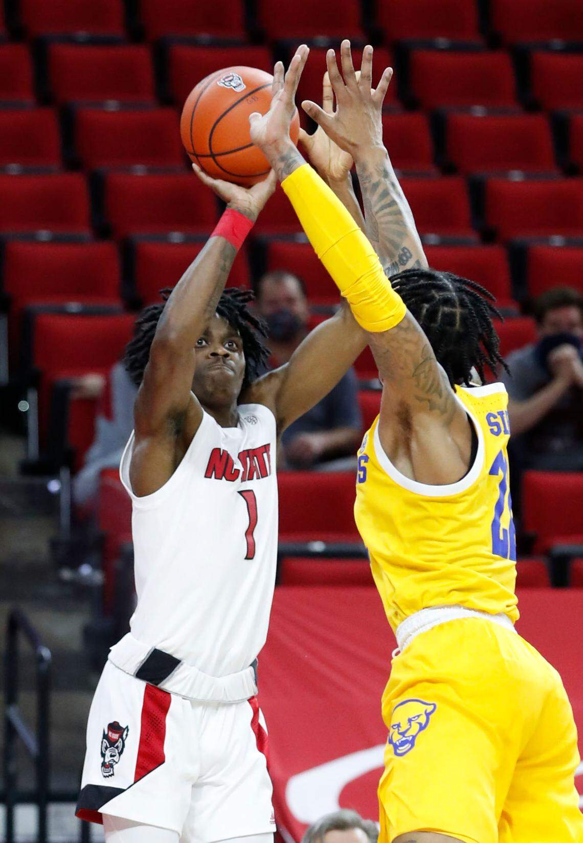 N.C. State’s Dereon Seabron (1) shoots as Pittsburgh’s Nike Sibande (22) defends during the first half of N.C. State’s game against Pittsburgh at PNC Arena in Raleigh, N.C., Sunday, February 28, 2021.