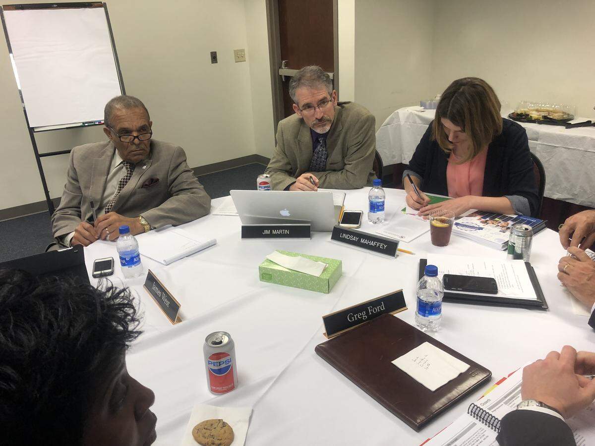 Seated left to right, Wake County Commissioner James West and Wake County school board members Jim Martin and Lindsay Mahaffey hear school staff members talk about funding needs at a joint meeting May 22, 2018 in Cary, N.C.