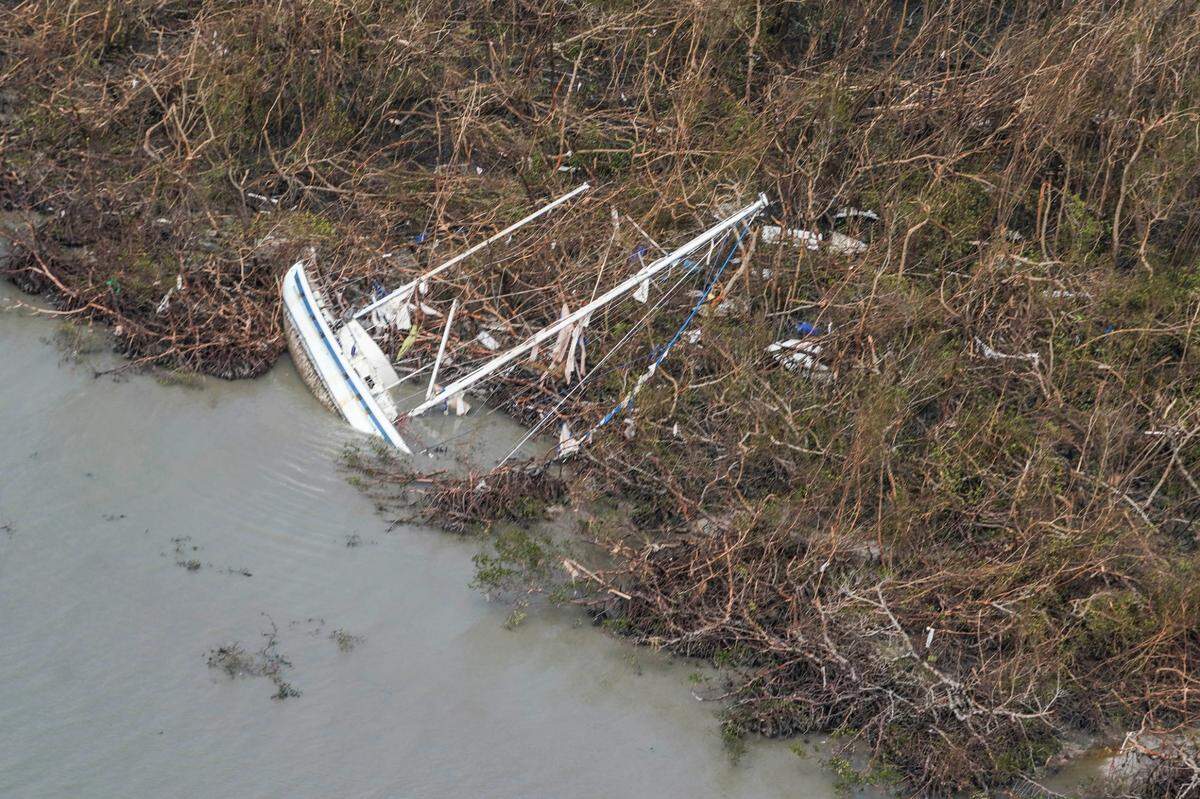 A damaged sailboat lies in water in the aftermath of Hurricane Ian, Thursday, Sept. 29, 2022, near Punta Gorda, Fla.