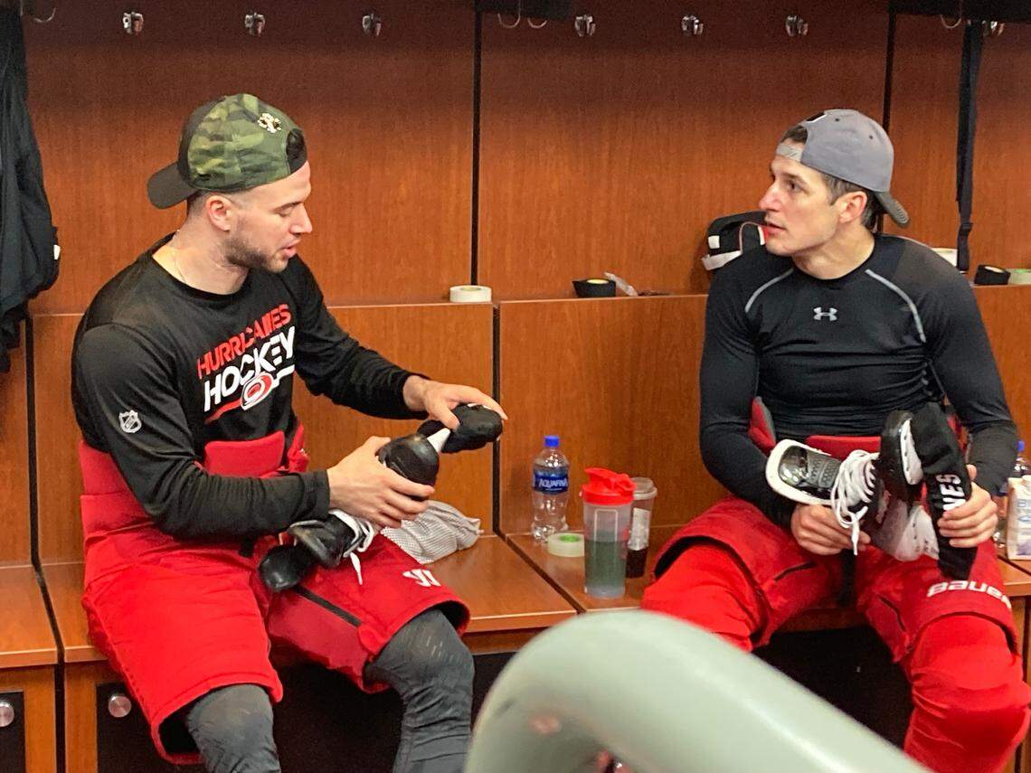 Carolina Hurricanes defensemen Tony DeAngelo, left, and Brady Skjei talk things over after practice at PNC Arena during the Stanley Cup playoffs on April 24, 2024.