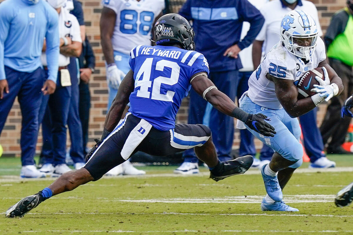 North Carolina Tar Heels running back Javonte Williams (25) runs away from Duke Blue Devils linebacker Shaka Heyward (42) during the second half at Wallace Wade Stadium. 