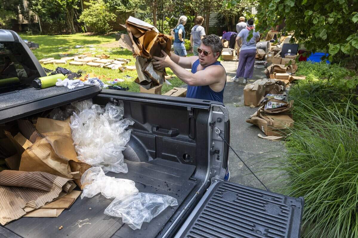Taylor Poston loads debris from a storm damaged home on Ridgefield Road on Tuesday, July 8, 2025, in Chapel Hill, N.C. The home was damaged by Tropical Strom Chantal from the flood waters of Booker Creek.