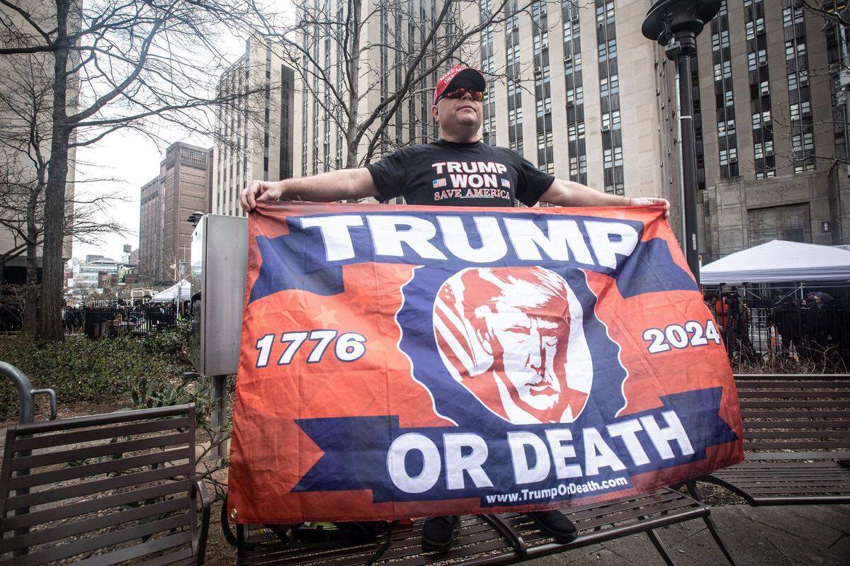 Trump supporter Dion Cini of Brooklyn holds a sign across the street from the Manhattan Criminal Courthouse April 4, 2023.