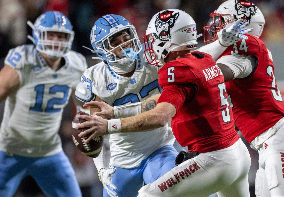 North Carolina’s Cedric Gray (33) pressures N.C. State quarterback Brennan Armstrong (5) in the first quarter on Saturday, November 25, 2023 at Carter-Finley Stadium in Raleigh, N.C.