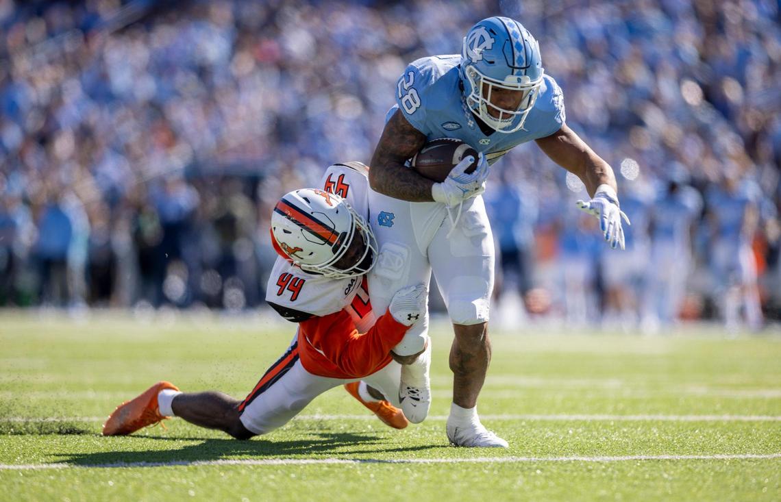 Campbell’s Ed Dennis (44) works to slow North Carolina’s Omarion Hampton (28) as he romps ten yards to set up a touchdown, giving the Tar Heels’ a 28-7 lead over Campbell in the second quarter on Saturday, November 4. 2023 at Kenan Stadium n Chapel Hill, N.C.