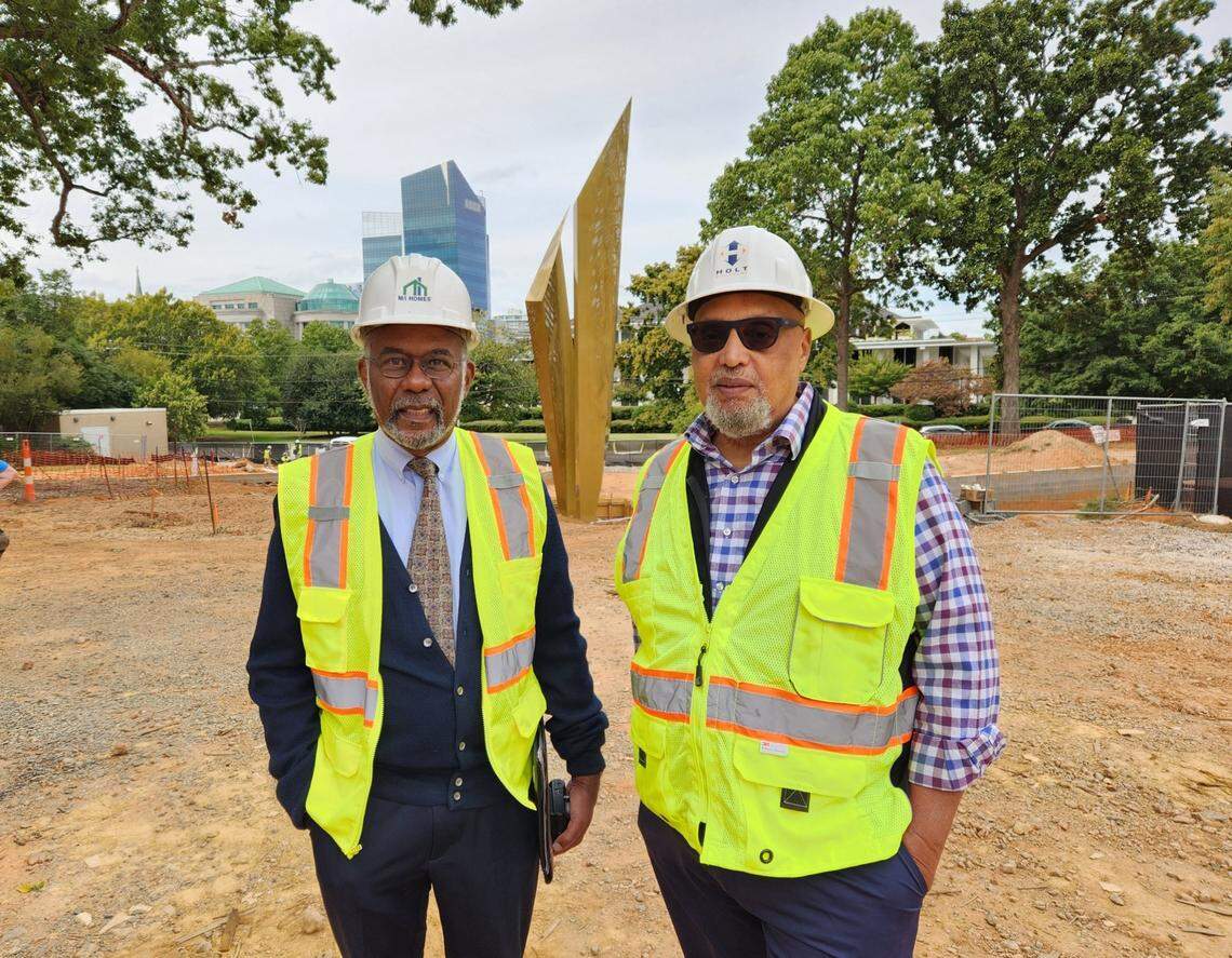 North Carolina Freedom Park board members Reginald Hildebrand, left, and Reggie Hodges, right, at the construction site of the park on Sept. 29, 2022, with the Beacon of Freedom inspirational public art behind them, which was recently installed. The park is slated to open mid-2023 in downtown Raleigh, N.C.