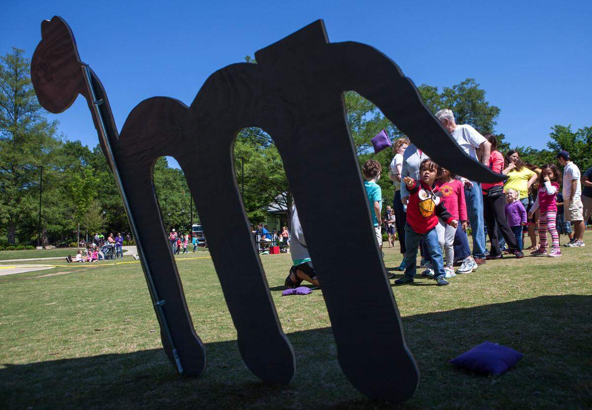 Seth Aldianto, 4, tosses a bean bag at a letter “M” for “Munching Mike” during Letterland Adventure Day at Pullen Park on May 17, 2014 in Raleigh. The Wake County Public School System, WAKE Up and Read, and Raleigh Parks and Recreation worked together to bring characters from the popular phonics program to life.