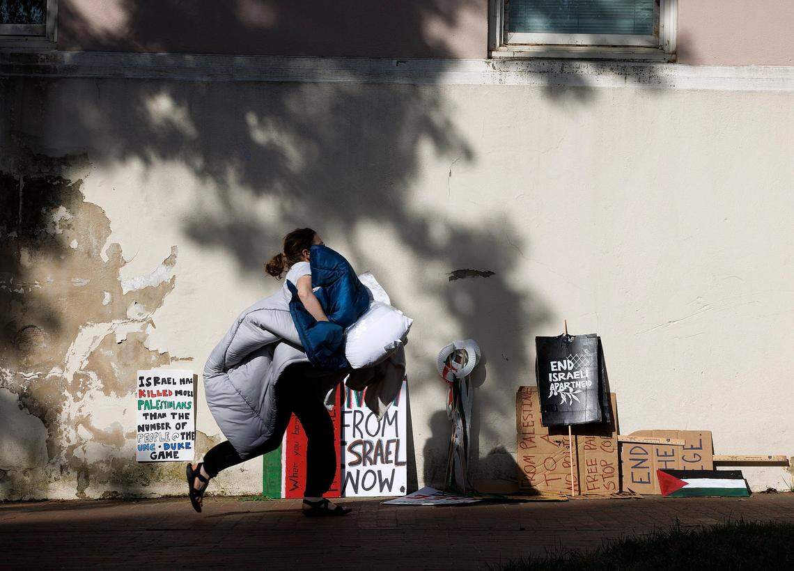 A person walks by signs outside of the Campus Y building hours after UNC-Chapel Hill police detained members of a pro-Palestinian “Gaza solidarity encampment” early Tuesday morning, April 30, 2024, after warning the group to remove its tents from university grounds or face possible arrest, suspension or expulsion from the university.