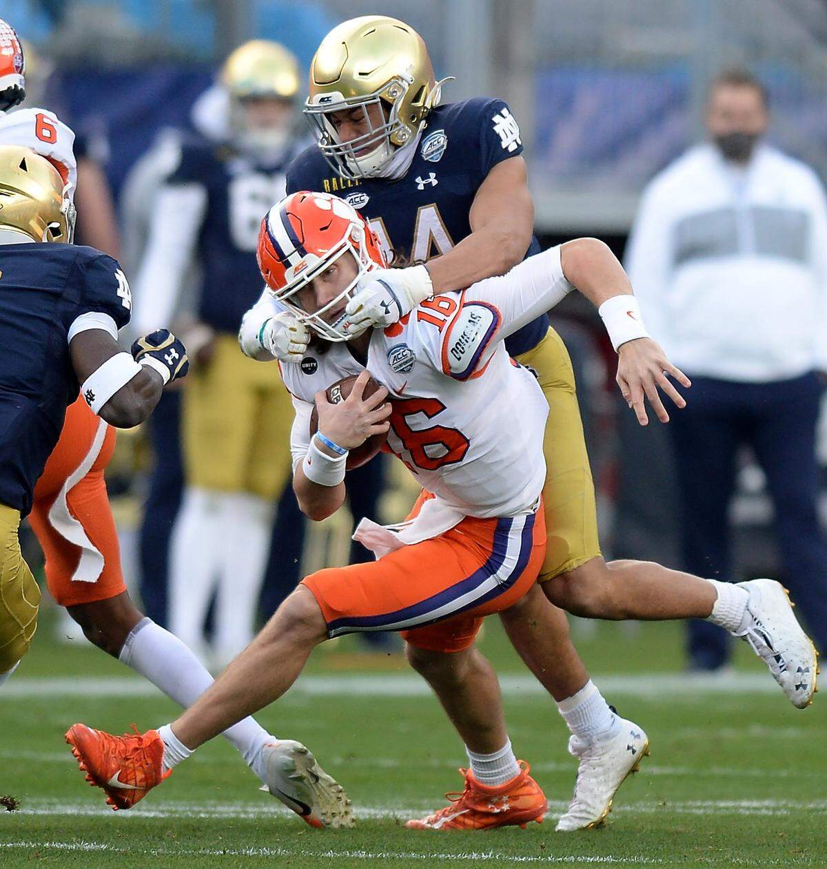 Clemson Tigers quarterback Trevor Lawrence is face masked by Notre Dame safety Kyle Hamilton on a run during first quarter action at Bank of America Stadium on Saturday, December 19, 2020 in Charlotte, NC. The Clemson Tigers and Notre Dame Fighting Irish faced off in the ACC Championship game.