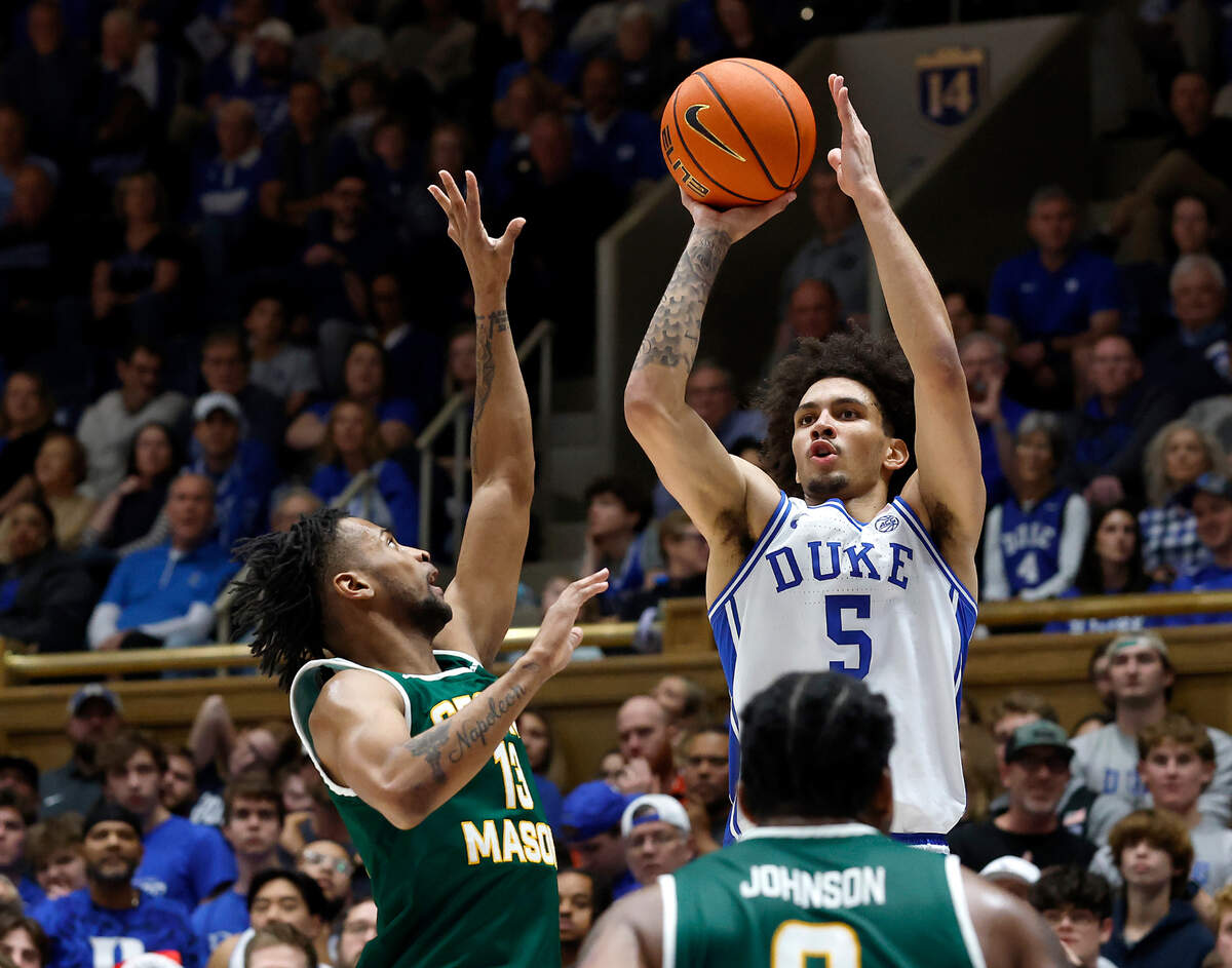 Duke’s Tyrese Proctor shoots over George Mason’s Darius Maddox and K.D. Johnson during the first half of the Blue Devils’ game on Tuesday, Dec. 17, 2024, at Cameron Indoor Stadium in Durham, N.C.