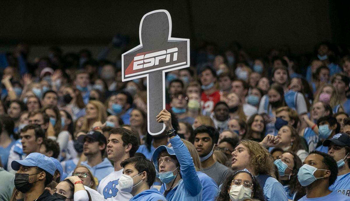 A fan in the North Carolina student section hoists an ESPN microphone in honor of Dick Vitale, who was introduced to the crowd before calling the North Carolina vs. Michigan game on Wednesday, December 1, 2021 at the Smith Center in Chapel Hill, N.C.
