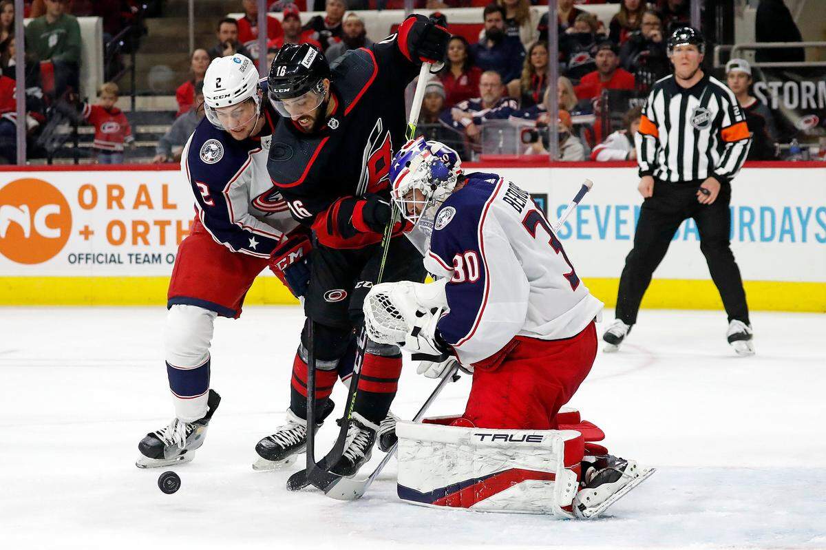 Carolina Hurricanes’ Vincent Trocheck (16) drives the puck between Columbus Blue Jackets’ Andrew Peeke (2) and goaltender J-F Berube (30) during the second period of an NHL hockey game in Raleigh, N.C., Friday, Feb. 25, 2022. (AP Photo/Karl B DeBlaker)