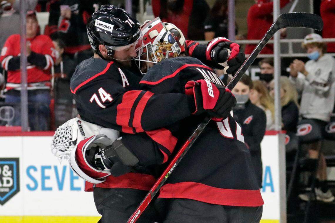 Carolina Hurricanes defenseman Jaccob Slavin (74) hugs goaltender Antti Raanta (32) at the end of an NHL hockey game against the Chicago Blackhawks, Friday, Oct. 29, 2021, in Raleigh, N.C. (AP Photo/Chris Seward)