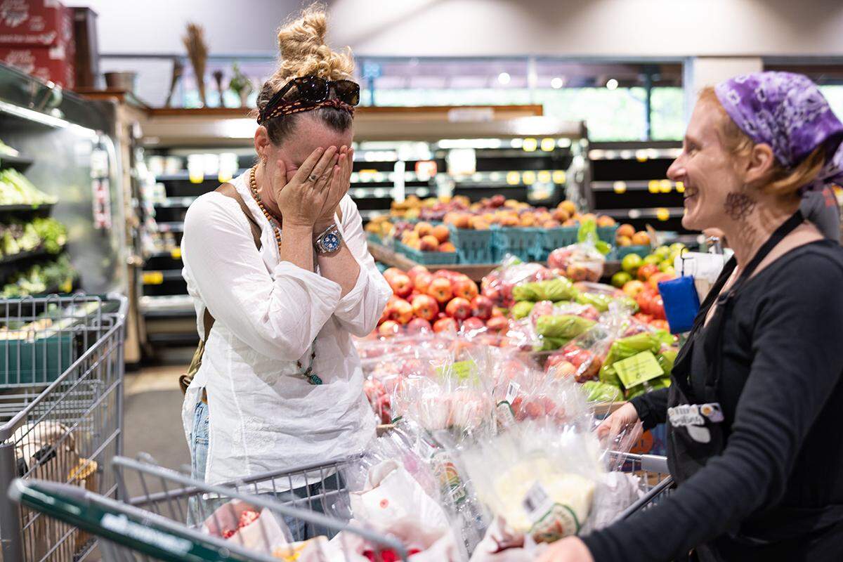 Prema Posner, left, becomes emotional after Emmaleigh Argonauta offered her free flowers at Whole Foods in Asheville, N.C. on Tuesday, October 1, 2024.