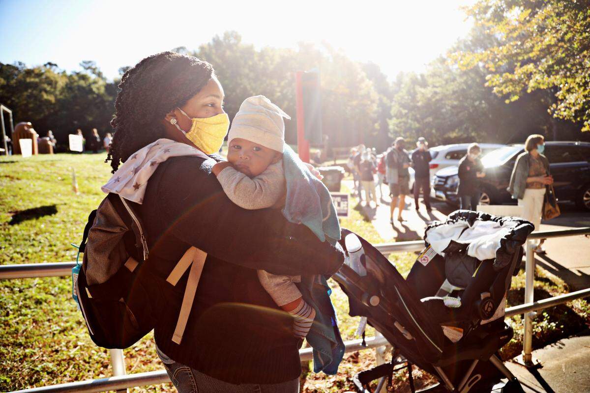 Ashley McNair holds her 10-week-old son, Carter, as she waits in line to vote at Lake Lynn Community Center on Thursday morning, Oct. 15, 2020. “This is important,” says McNair, who got in line early with her husband and nine-year-old daughter.