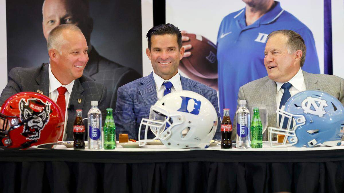 N.C. State head coach Dave Doeren, left, Duke head coach Manny Diaz, center, and North Carolina head coach Bill Belichick laugh as they talk with each other during the Bill Dooley Pigskin Preview at the Hilton Raleigh North Hills on Friday, July 25, 2025.