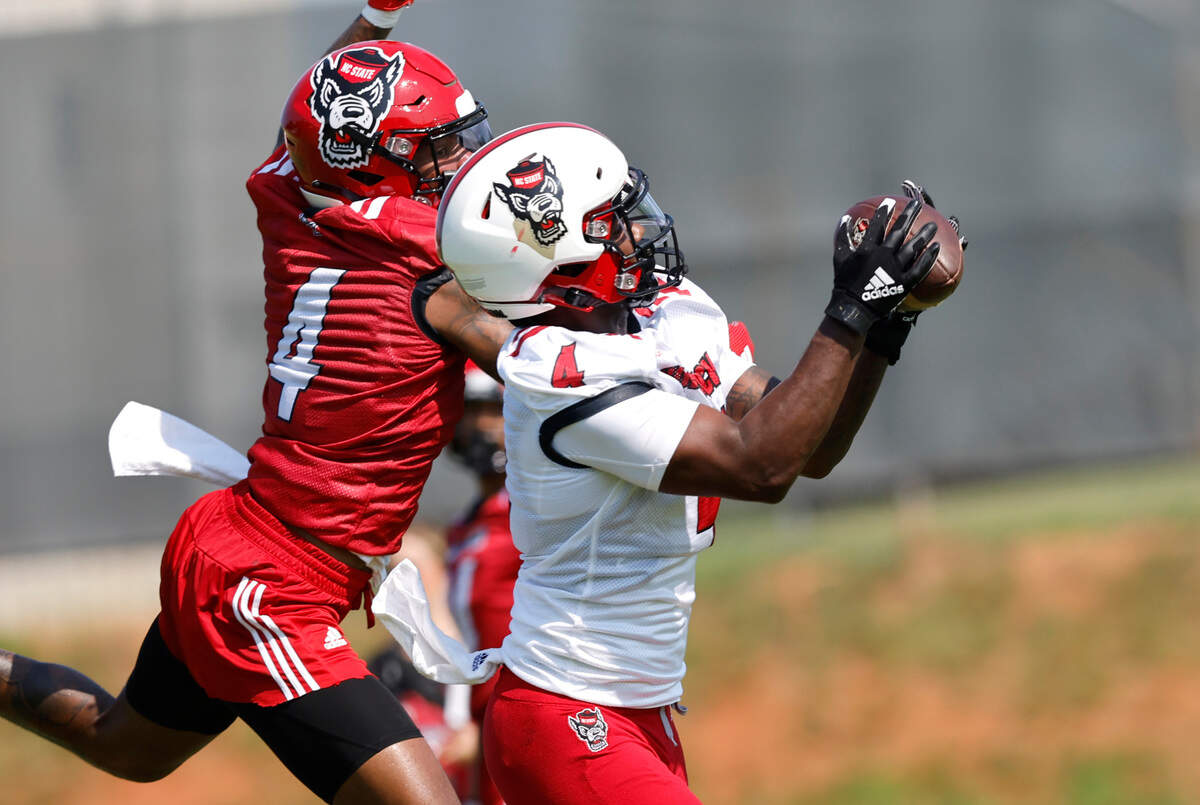 N.C. State wide receiver Porter Rooks (4) pulls in a pass while defended by safety Cyrus Fagan (4) during the Wolfpack’s first practice of fall camp in Raleigh, N.C., Wednesday, August 3, 2022.