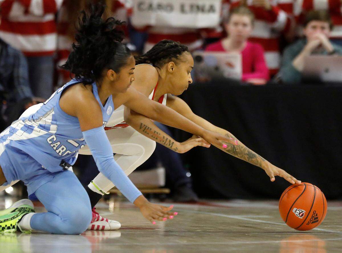 North Carolina’s Deja Kelly and N.C. State’s Aziaha James dive on the floor during the second half of the Wolfpack’s 63-59 win on Thursday, Feb. 1, 2024, at Reynolds Coliseum in Raleigh, N.C.