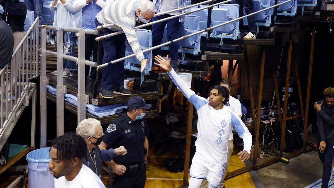 Roy Williams gives North Carolina’s Caleb Love a high-five as the team runs out onto the court before UNC’s game against Boston College at the Smith Center in Chapel Hill, N.C., Wednesday, Jan. 26, 2022.
