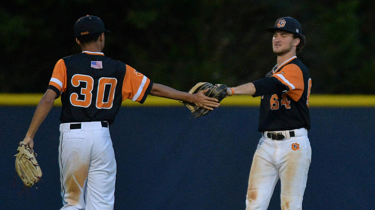 Fuquay-Varina’s Garrett McCraw (64) congratulates teammate TJ Hardy (3) after his diving catch. The Fuquay-Varina Bengals and the Leesville Road Pride met in the first round of the NCHSAA 4A baseball playoffs in Raleigh, N.C. on May 7, 2019.