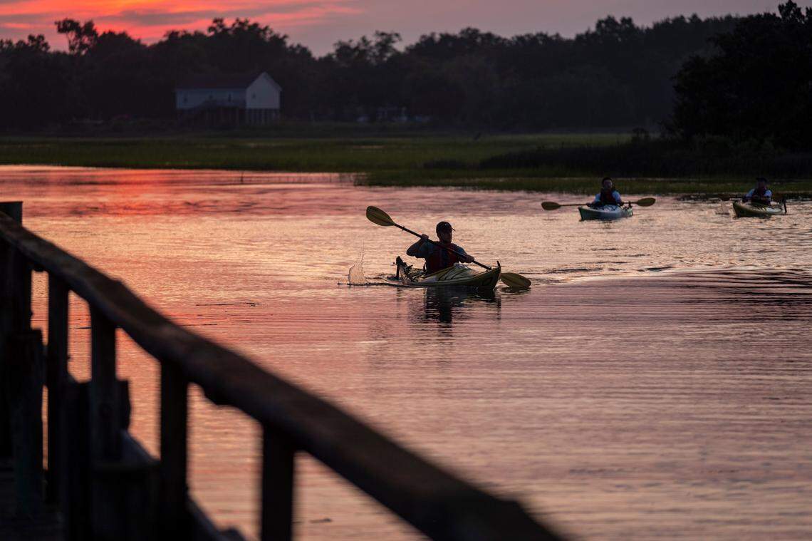 Kayakers return from a sunset paddle around BowenÕs Island on the Folly River.