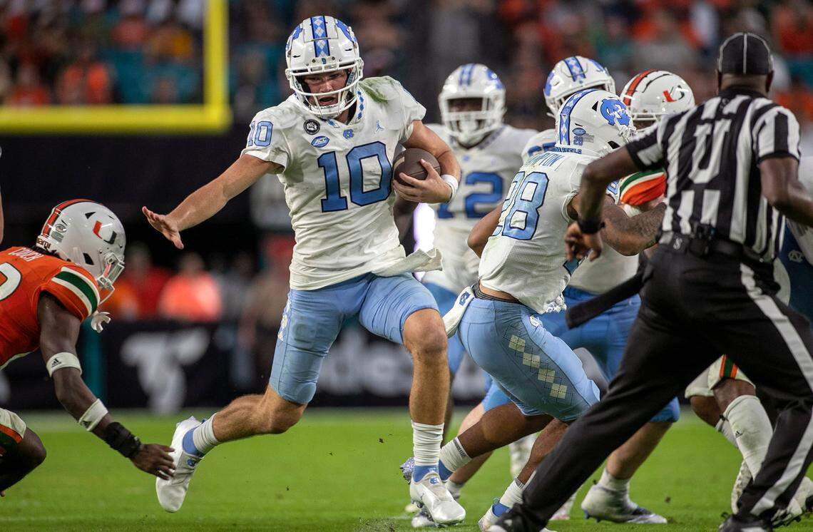 North Carolina quarterback Drake Maye (10) rushes for 11 yards in the fourth quarter ahead of Miami’s Te’Cory Couch (23) on Saturday, October 8, 2022 at Hard Rock Stadium in Miami Gardens, Florida. Maye rushed for 53 yards in the Tar Heels’ victory.