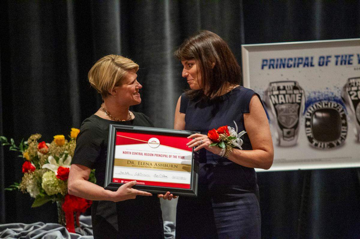 Elena Ashburn, the principal of Broughton High School in Raleigh, right, accepts an award from Superintendent of Public Instruction of North Carolina Catherine Truitt before Ashburn was named the 2021 Wells Fargo North Carolina Principal of the Year during a banquet at the Umstead Hotel and Spa in Cary Friday, May 21, 2021.