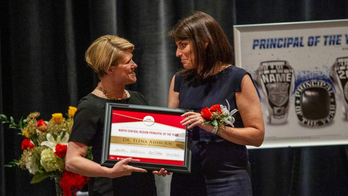 Elena Ashburn, the principal of Broughton High School in Raleigh, right, accepts an award from Superintendent of Public Instruction of North Carolina Catherine Truitt before Ashburn was named the 2021 Wells Fargo North Carolina Principal of the Year during a banquet at the Umstead Hotel and Spa in Cary Friday, May 21, 2021.