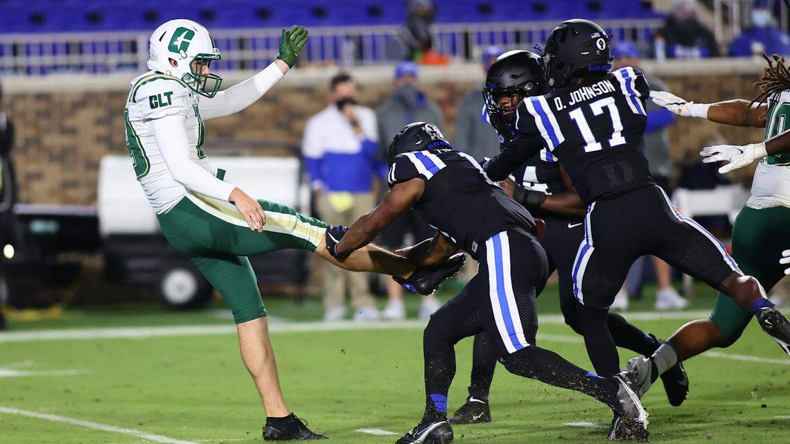 Charlotte 49ers punter Connor Bowler (19) has his punt blocked blocked by Duke Blue Devils safety Isaiah Fisher-Smith (11) during the first quarter of the game against the Charlotte 49ers at Wallace Wade Stadium.