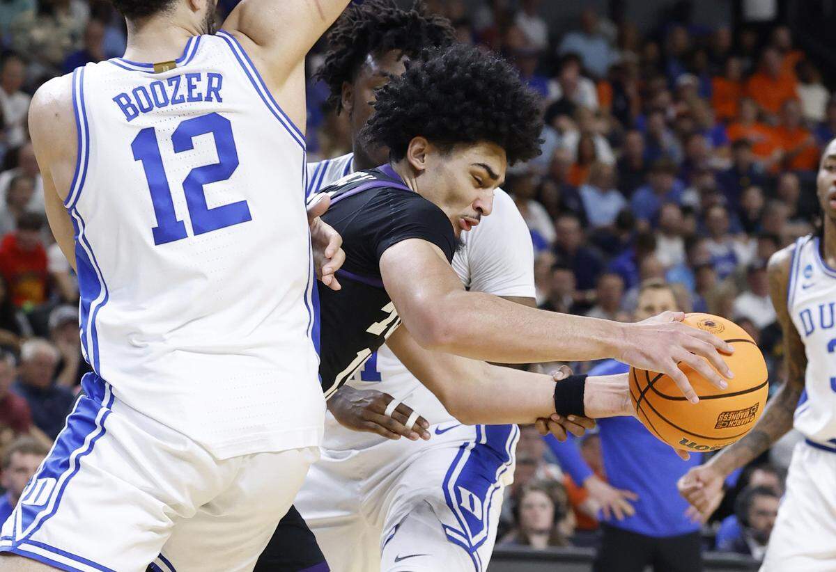 TCU’s David Punch (15) tries to get through the defense of Duke’s Patrick Ngongba (21) and Cameron Boozer (12) during the first half of Duke’s game against TCU in the second round of the NCAA Men’s Basketball Tournament at  Bon Secours Wellness Arena in Greenville, S.C., Saturday, March 21, 2026.