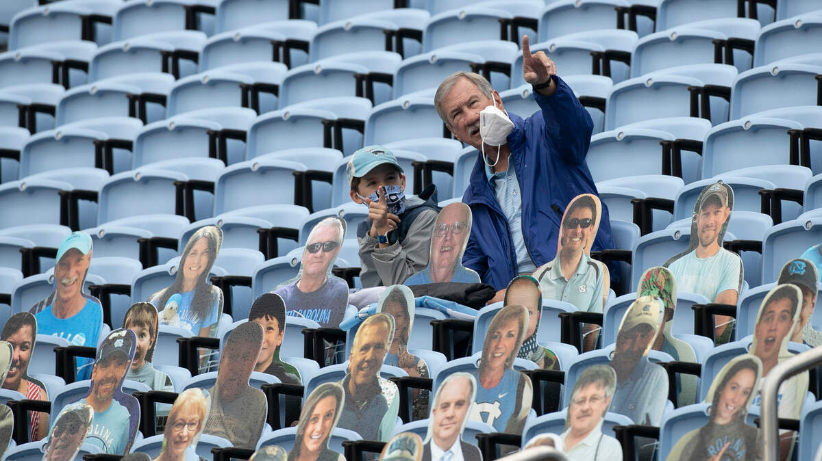 Charles Gainey of Clinton, N.C. and his grandson Graham Hardison of Apex, N.C. watch the Tar Heels’ warm up for their game against Virginia Tech on Saturday, October 10, 2020 at Kenan Stadium in Chapel Hill, N.C. Under new COVID-19 guidelines 3500 people were allowed into the stadium for the game Saturday.