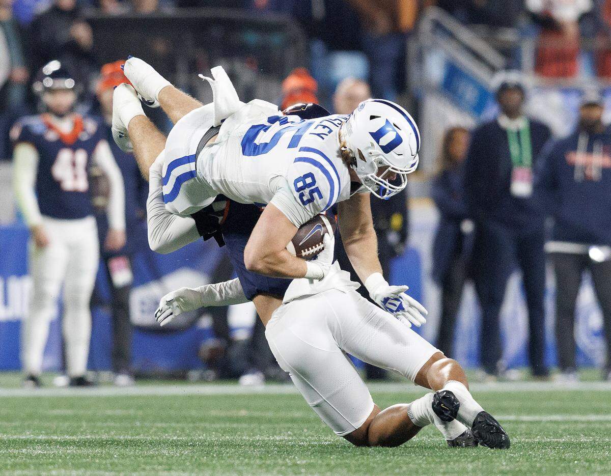 Duke’s Jeremiah Hasley is tackled by Virginia’s Landon Danley during the first half of the ACC Football Championship on Saturday, Dec. 6, 2025, at Bank of America Stadium in Charlotte, N.C.