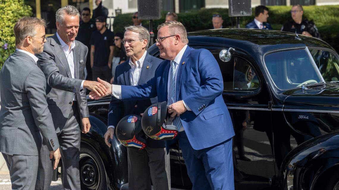 From left, Speedway Motorsports President and CEO Marcus Smith and NASCAR President Steve Phelps present Senate Majority Leader Paul Newton and House Speaker Tim Moore with vintage-style racing helmets during an announcement Thursday, Sept 28, 2023 outside the North Carolina Legislative Building in downtown Raleigh, that the NASCAR All-Star Race will be held May 17-19 at the North Wilkesboro Speedway.