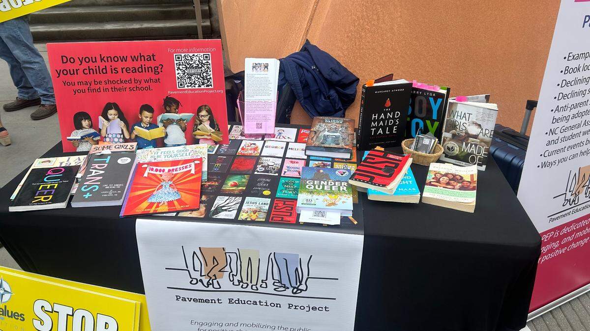 The Pavement Education Project displays books it says are not appropriate to be in schools at a news conference at Freedom Park in Raleigh, N.C., on May 15, 2024. The  group is now helping parents by providing forms they can use to opt out of school assignments for religious reasons or because it involves LGBTQ+ content.