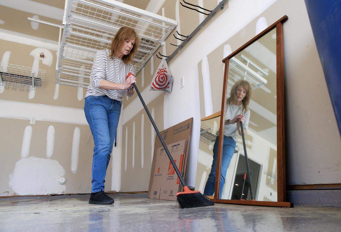 Jill Rohner sweeps debris in the garage while working to move out of her former home on Wednesday, May 28, 2025, in Raleigh, N.C. Rohner’s partner was fatally shot by her ex-husband, against whom she had a domestic violence protective order, at the home in late January. 