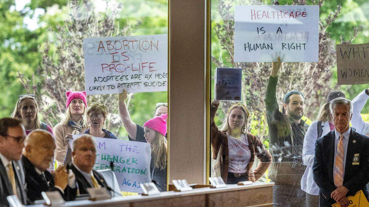 Demonstrators hold signs outside the legislature auditorium where a House Rules meeting&nbsp;was underway, May 3, 2023 at the Legislative Building. Republican state lawmakers announced their plan to limit abortion rights across the state.