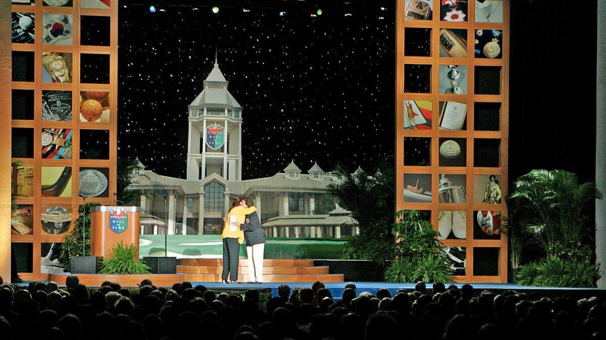 FILE - LPGA Tour Commissioner Carolyn Bivens, left, and Hall of Fame golfer Nancy Lopez embrace during Hall of Fame induction ceremonies at the World Golf Hall of Fame in St. Augustine, Fla., Monday, Nov. 12, 2007. The World Golf Hall of Fame is leaving Florida and returning to North Carolina, where it will be part of the USGA’s campus at Pinehurst. Jay Monahan, the PGA Tour commissioner who chairs the World Golf Foundation, said Wednesday’s, July 20, 2022, announcement would “cement the long-term relevance and viability” of the Hall of Fame and expand on the partnership with the USGA. (AP Photo/Jake Roth, File)
