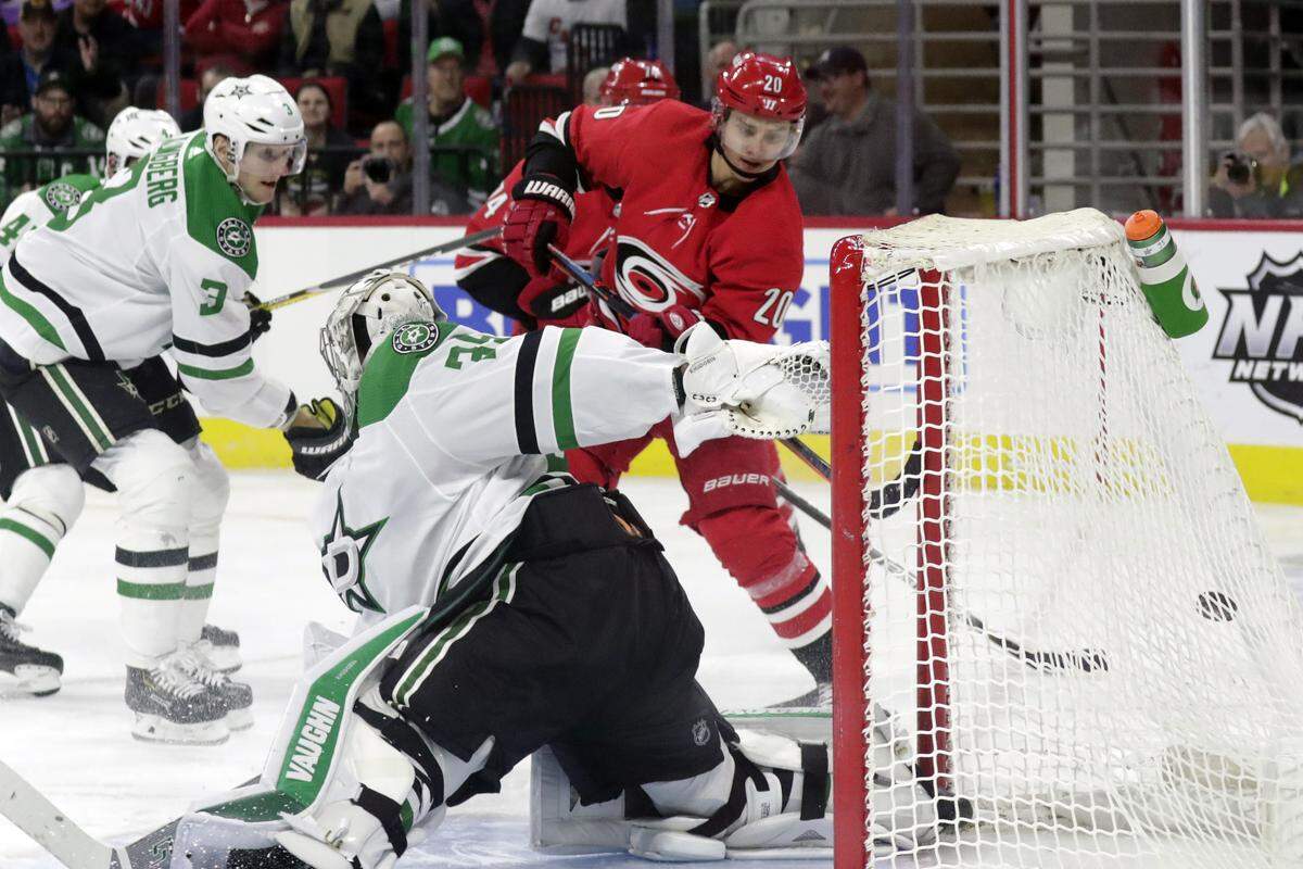 Carolina Hurricanes’ Sebastian Aho (20) scores against Dallas Stars’ John Klingberg (3) and Anton Khudobin (35) during the second period of an NHL hockey game in Raleigh, N.C., on Tuesday, Feb. 25, 2020. (AP Photo/Chris Seward)