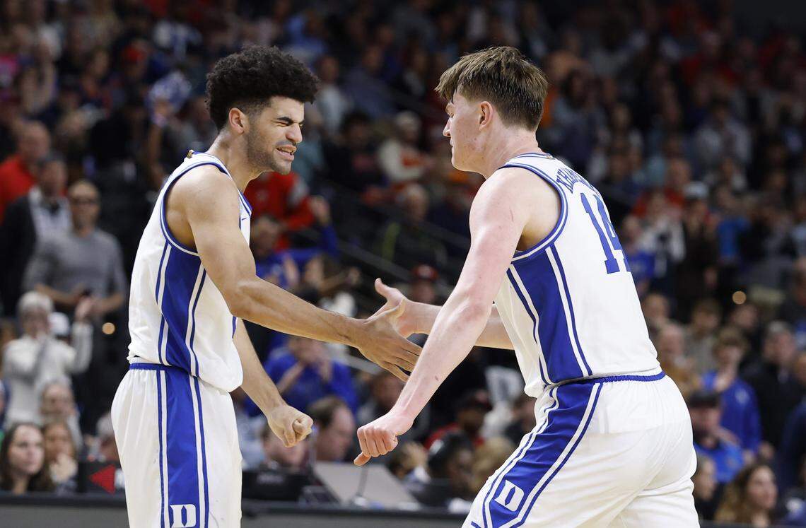 Duke’s Cayden Boozer (2) celebrates with Nikolas Khamenia (14) during the second half of Duke’s 71-65 victory over Siena in the first round of the NCAA Men’s Basketball Tournament at Bon Secours Wellness Arena in Greenville, S.C., Thursday, March 19, 2026.