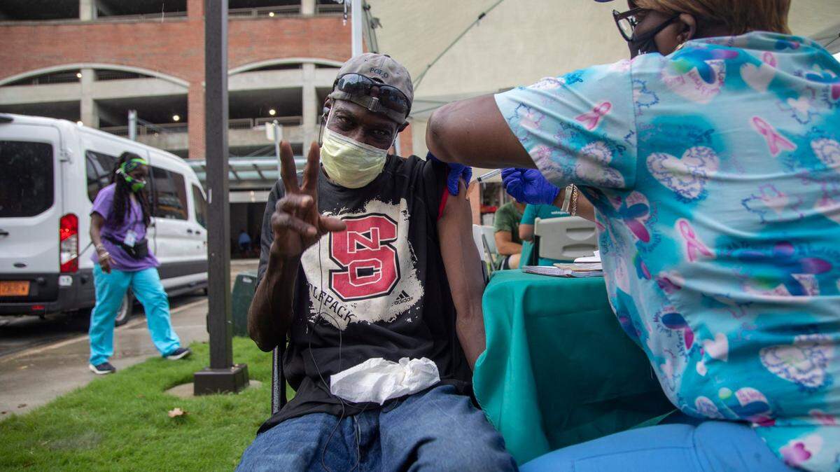 Medical Assistant Charlene Blount administers a COVID-19 vaccine to Darnell Hinton Tuesday, August 17, 2021 during a mobile vaccine clinic at the Go Raleigh bus station in downtown Raleigh.
