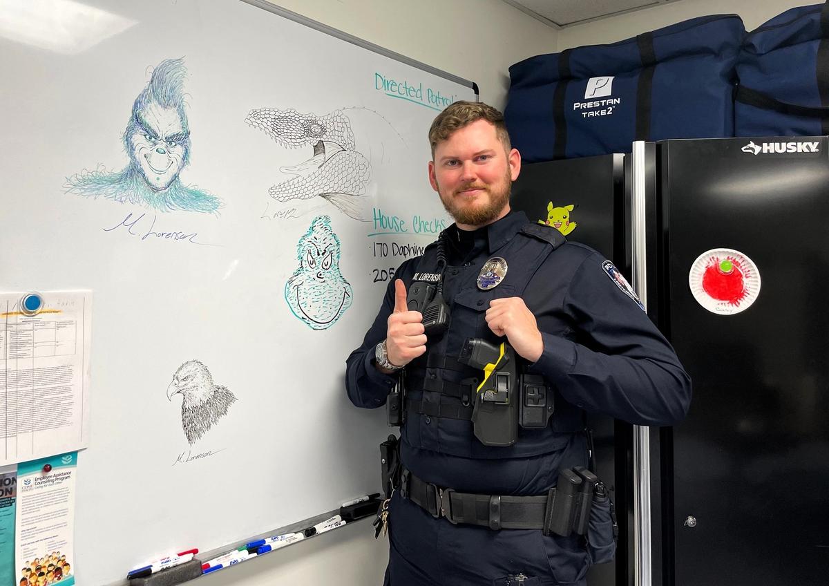 Officer 1st Class Matthew Lorenson shows off some of his latest doodles on a whiteboard in the Hillsborough Police Department. The now-weekly doodle art started as an attempt to one-up a co-worker who drew the Dr. Suess-era Grinch at the center of the board.