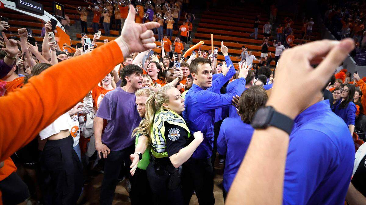 Fans storm the court as Duke staff try to keep them from the players after Clemson’s 77-71 victory over Duke at Littlejohn Coliseum in Clemson, S.C., Saturday, Feb. 8, 2025.