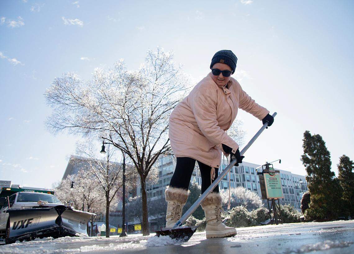 Rebecca Petrohoy shovels ice from the sidewalk in downtown Durham, N.C. on Saturday, Jan. 11, 2025.