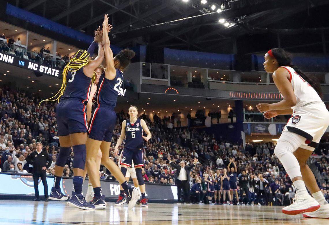 N.C. State’s Elissa Cunane (33) is defended by Connecticut’s Aaliyah Edwards (3) and Olivia Nelson-Ododa (20) before she passes to Kayla Jones (25) during the University of Connecticut’s 91-87 double overtime victory over N.C. State in the Bridgeport Regional final at Total Mortgage Arena in Bridgeport, Conn., Monday, March 28, 2022.