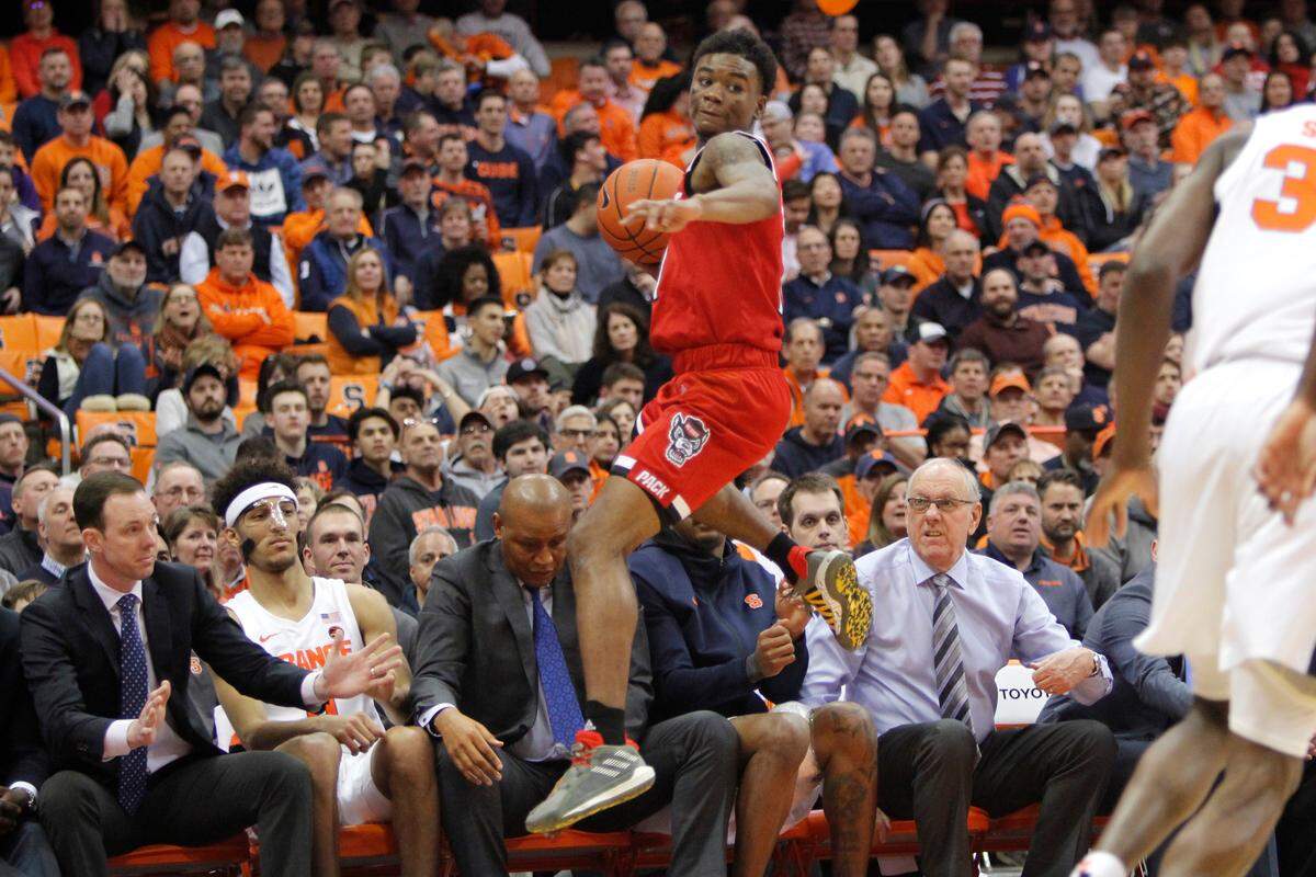 North Carolina State’s Markell Johnson jumps in front of the Syracuse bench for a loose ball in the second half of an NCAA college basketball game in Syracuse, N.Y., Tuesday, Feb. 11, 2020. North Carolina State won 79-74.