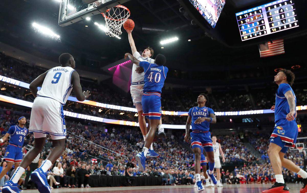 Duke’s Cooper Flagg (2) goes over Kansas’ Flory Bidunga (40) to slam in two during Kansas’ 75-72 victory over Duke in the Vegas Showdown at T-Mobile Arena in Las Vegas, Nev., Tuesday, Nov. 26, 2024.